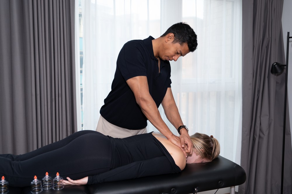 Joel Nathan treating a patient's neck and upper back on the treatment table