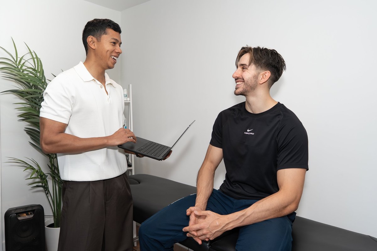 Joel Nathan talking through a patient's treatment plan with a laptop in the Birmingham clinic