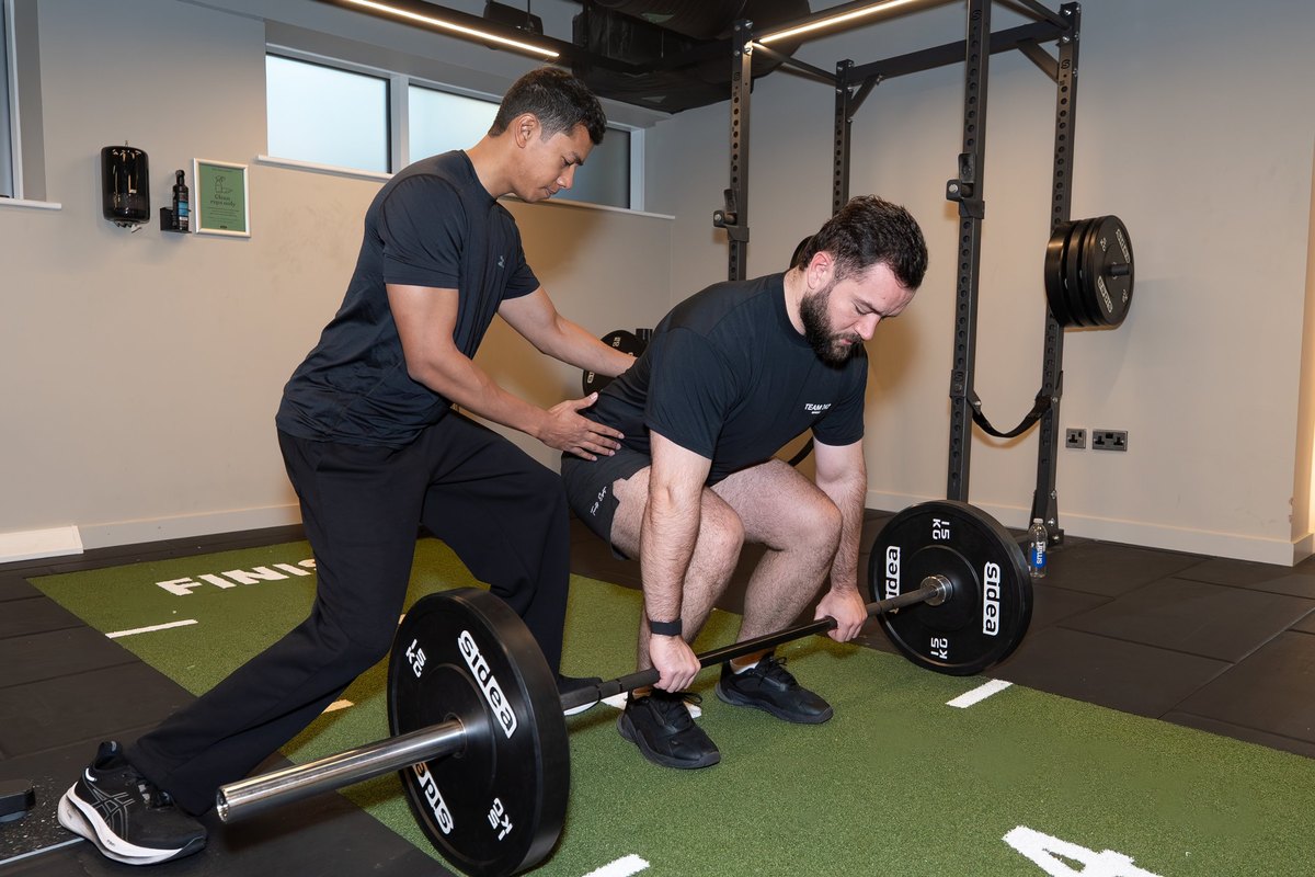 Joel Nathan coaching barbell deadlift technique in the gym