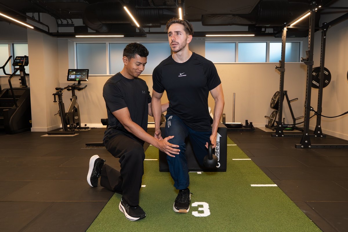 Joel Nathan coaching a split squat step-up with a kettlebell on a box