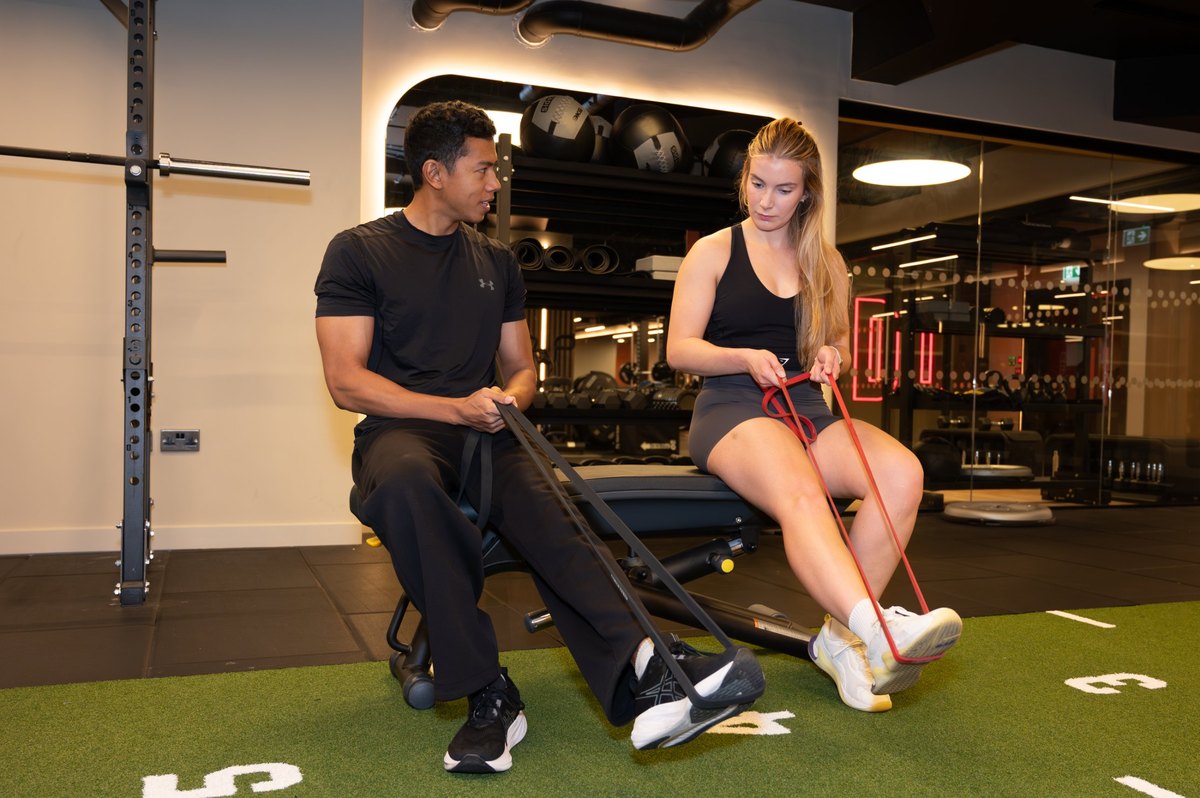 Joel Nathan coaching resistance band technique during a rehab session