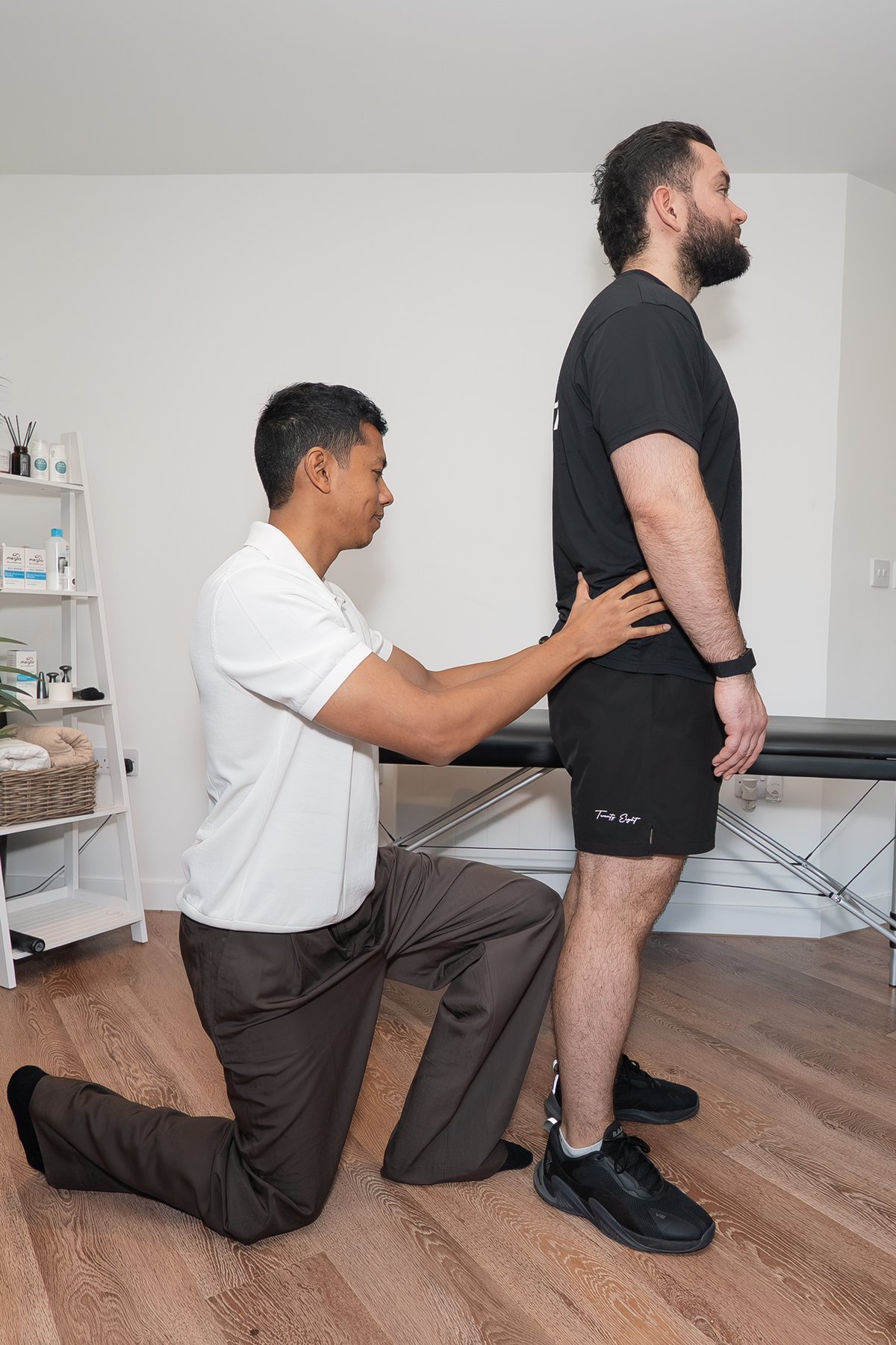 Joel Nathan carrying out a standing posture assessment with a patient