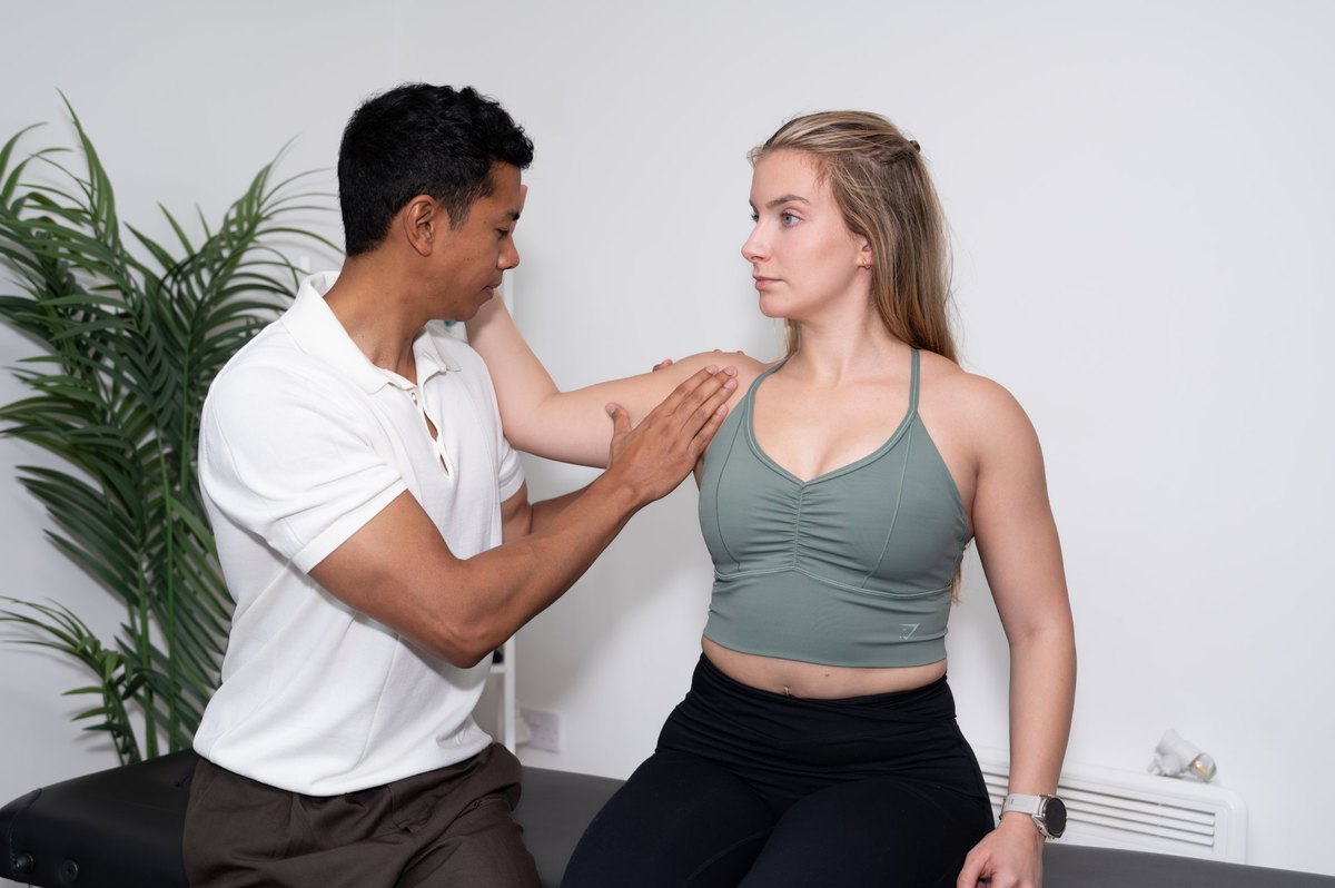 Joel Nathan talking through a treatment plan with a seated patient in the clinic