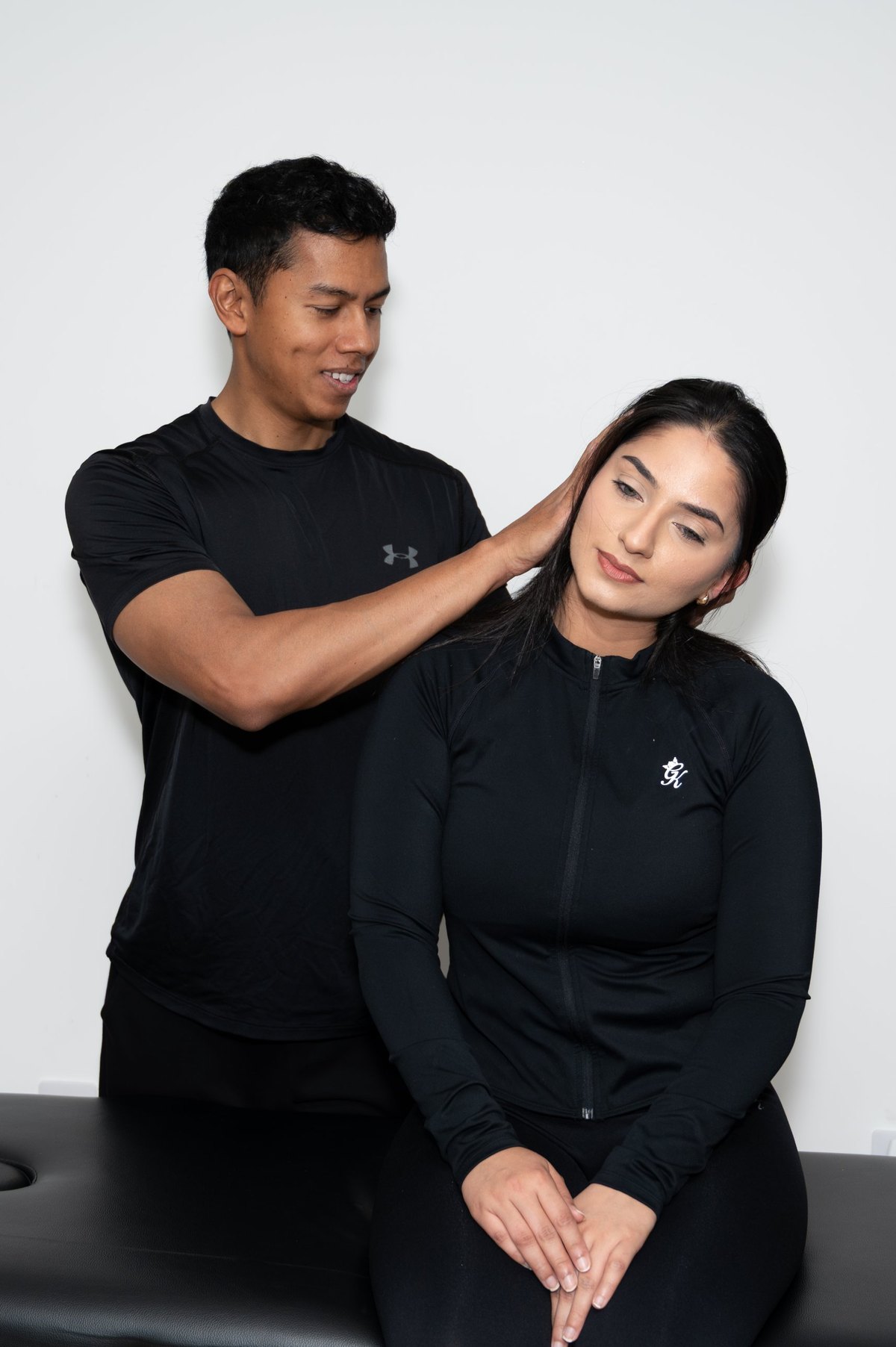 Joel Nathan guiding a patient through a standing shoulder stretch assessment
