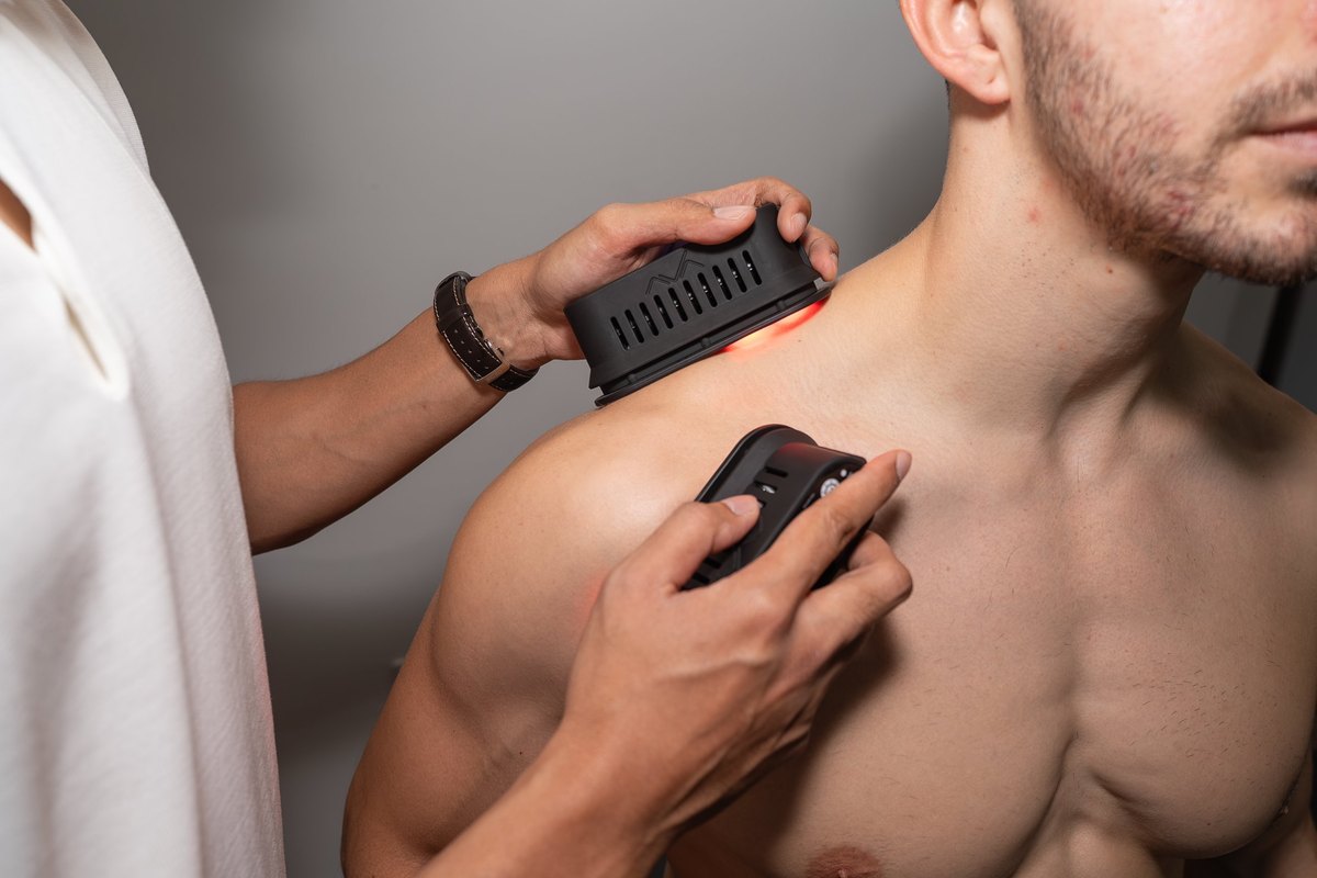 Close-up of red light therapy devices being applied to a patient's shoulder